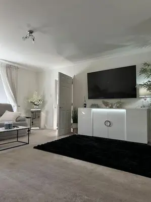 a living room with a flat screen tv on the wall at 3 double bedroom spacious flat in Largs