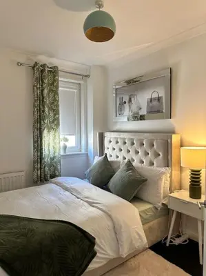 a bedroom with a white bed with a window at 3 double bedroom spacious flat in Largs