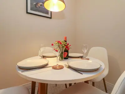 a white table with plates and glasses and flowers on it at Seaview Lismore House in Oban