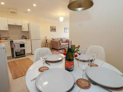 a white table with a bottle of wine and glasses at Seaview Lismore House in Oban