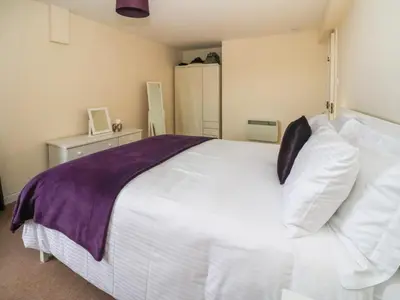 a bedroom with a large white bed with pillows at Seaview Lismore House in Oban
