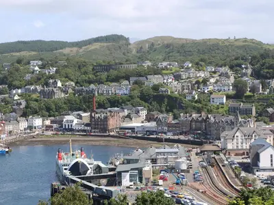 a town on a river with a boat in the water at Seaview Lismore House in Oban