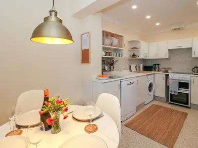 a kitchen with a table and chairs and a kitchen with white cabinets at Seaview Lismore House in Oban