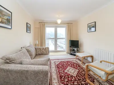 a living room with a couch and a tv at Seaview Lismore House in Oban