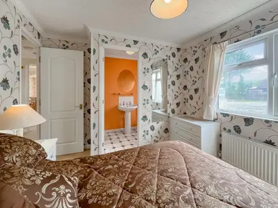 a bedroom with a bed and a bathroom at Tredegar in Newton Stewart