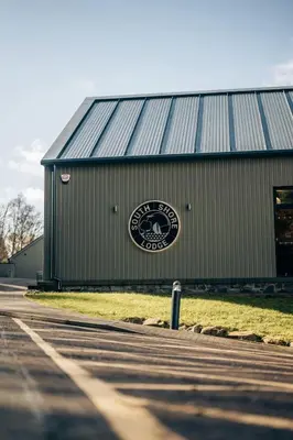 a barn with a sign on the side of it at Loch Earn leisure park in Saint Fillans