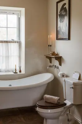 a bathroom with a tub and a toilet and a window at Rosebank Cottage - Hot Tub & Log Stove in Alexandria