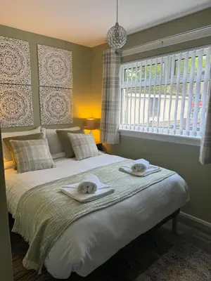 a bedroom with a bed with towels on it at Loch Lomond Riverside Apartments B in Balloch