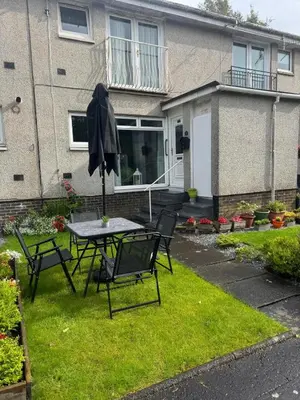 a table and chairs in the yard of a house at Loch Lomond Riverside Apartments B in Balloch
