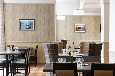 a dining room with tables and chairs at The Tarbet Hotel in Tarbet
