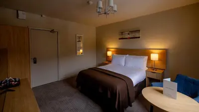 a hotel room with a bed and a table and a chair at The Tarbet Hotel in Tarbet