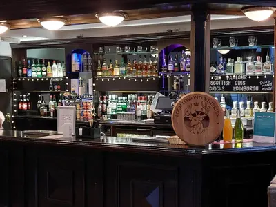 a bar with a lot of bottles of alcohol at The Tarbet Hotel in Tarbet