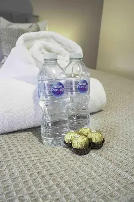 a bottle of water sitting on top of a bed at Scotia House in Larkhall
