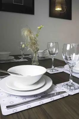 a table with a bowl and wine glasses on it at Strath Apartment in Strathaven