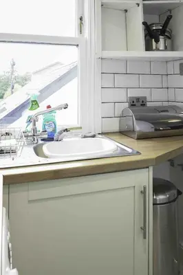 a kitchen counter with a sink and a window at Strath Apartment in Strathaven