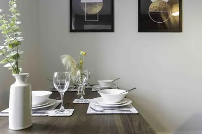 a dining room table with plates and glasses on it at Strath Apartment in Strathaven