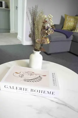 a book sitting on top of a table with a vase at Pentland House in Bathgate