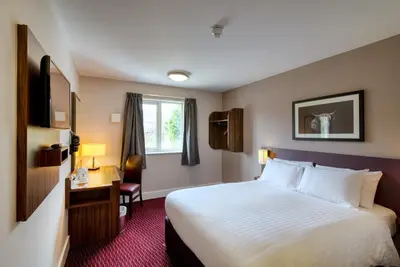 a hotel room with a bed and a desk at Queen of the Loch, Balloch by Marston's Inns in Balloch