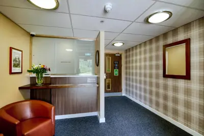 a waiting room with a chair and a mirror at Queen of the Loch, Balloch by Marston's Inns in Balloch
