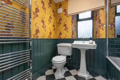 a bathroom with a toilet and a sink at Queensberry Cottage in Thornhill