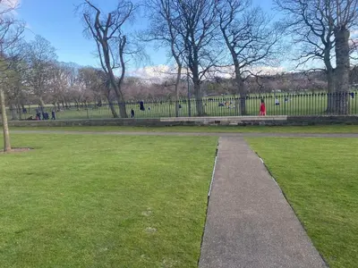 a path in a park with a person in the distance at Stunning park view Quartermile apartment close proximity to Castle University in Edinburgh