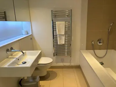 a bathroom with a sink and a toilet and a shower at Stunning park view Quartermile apartment close proximity to Castle University in Edinburgh