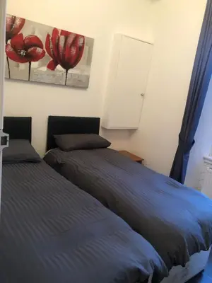 a bedroom with two beds and a painting of red flowers at Central Morrison Street Apartment in Edinburgh