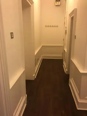 an empty hallway with white walls and wood floors at Central Morrison Street Apartment in Edinburgh