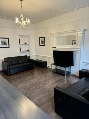 a living room with black furniture and a fireplace at Central Morrison Street Apartment in Edinburgh
