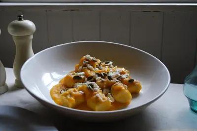 a white bowl of pasta with cheese on a table at The Cross Keys in Kippen in Kippen