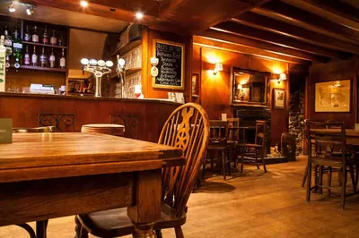 a restaurant with a wooden table and chairs and a bar at The Cross Keys in Kippen in Kippen