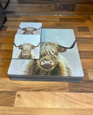 a book with a picture of a cow on the floor at Lademill Cottage in Aberfeldy