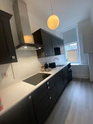 a kitchen with black cabinets and a white counter top at 4 Smithhills Central 2 bed sleeps 4 in Paisley