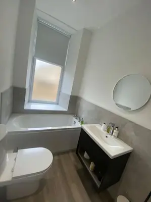 a bathroom with a toilet and a sink and a mirror at 4 Smithhills Central 2 bed sleeps 4 in Paisley