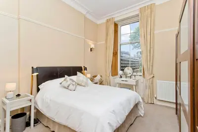 a bedroom with a large white bed and a window at Stylish Murrayfield sanctuary in Edinburgh
