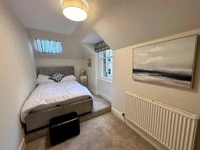 a small bedroom with a bed and a window at Stylish Murrayfield sanctuary in Edinburgh