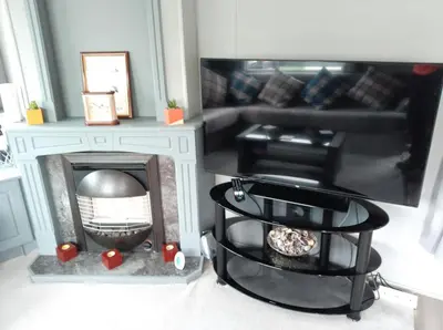 a living room with a fireplace and a couch at Cairnryan - Loch Ryan View in Cairnryan