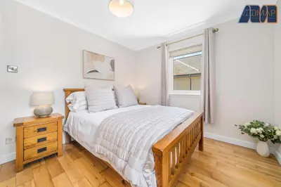 a bedroom with a large bed and a window at Large Family Home with Hot Tub or Jacuzzi, Log Burner in Bearsden