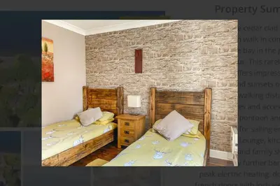 a bedroom with two beds and a stone wall at Picturesque beauty of Strachur in Strachur