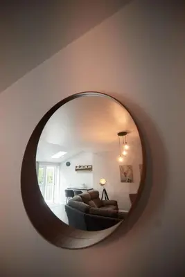 a mirror in a living room with a couch at A stunning And Slick Escape in Stonehouse