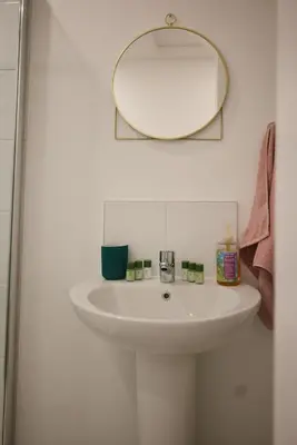 a bathroom with a white sink and a mirror at A stunning And Slick Escape in Stonehouse