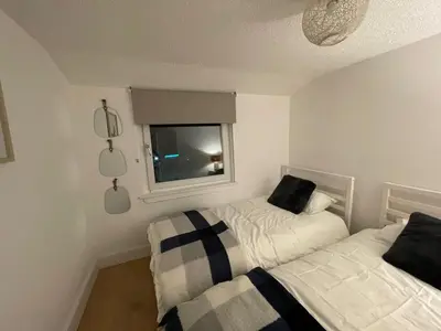 a bedroom with two beds and a window at Largs 2 bedroom Apartment in Largs