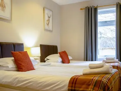 a room with three beds with red pillows on them at Cairnies - Uk47886 in Keilour