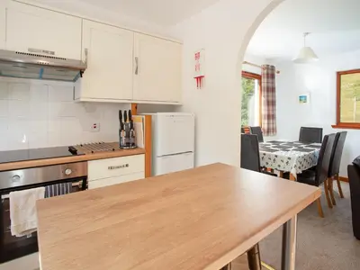 a kitchen with a wooden table and a kitchen with a dining room at Aonach Cottage - Uk41932 in Glencoe