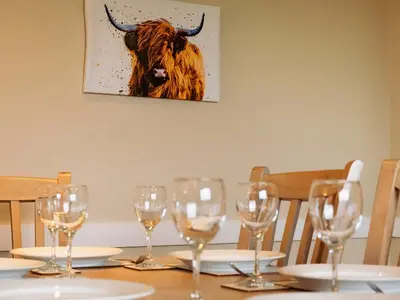 a table with wine glasses and a cow on the wall at Ninetrees - Uk47883 in Keilour
