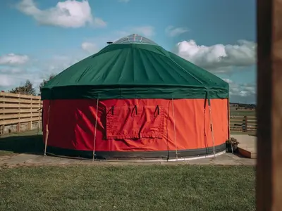 a green and red tent in the grass at Moss Yurt - Uk47888 in Keilour