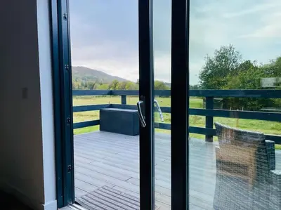 a sliding glass door with a view of a deck at Riverview Lodge & Luxury Hot Tub in Acharra