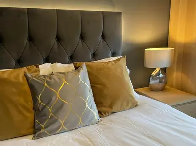 a bed with two pillows and a lamp on a table at Riverview Lodge & Luxury Hot Tub in Acharra
