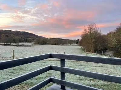 a view of a field with snow on the ground at Riverview Lodge & Luxury Hot Tub in Acharra