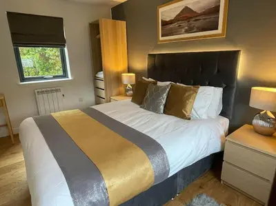a bedroom with a large bed and a window at Riverview Lodge & Luxury Hot Tub in Acharra